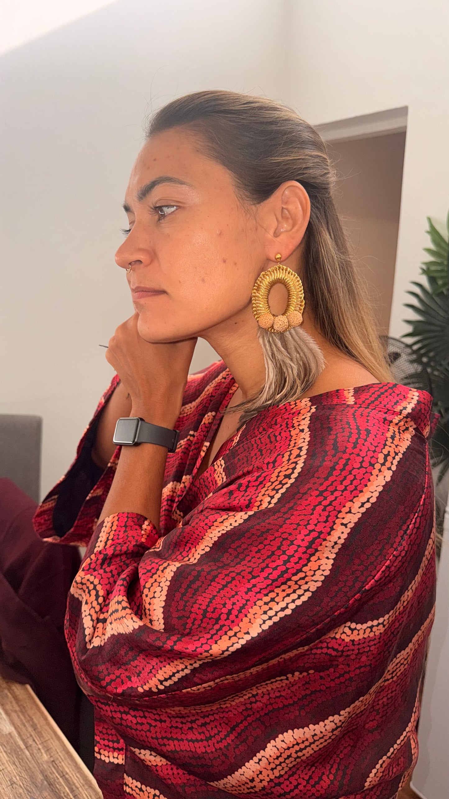 Aboriginal Woman wearing Aboriginal designed kimono and woven gold earrings with emu feathers 