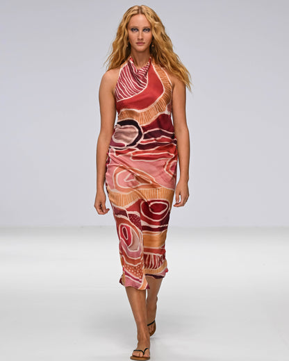 A Woman in a First Nations designed dress walking down a catwalk