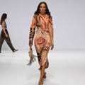 Model walking on a runway wearing a Aboriginal artwork dress.