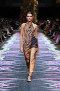 Aboriginal Woman in a First Nations designed dress walking down a runway