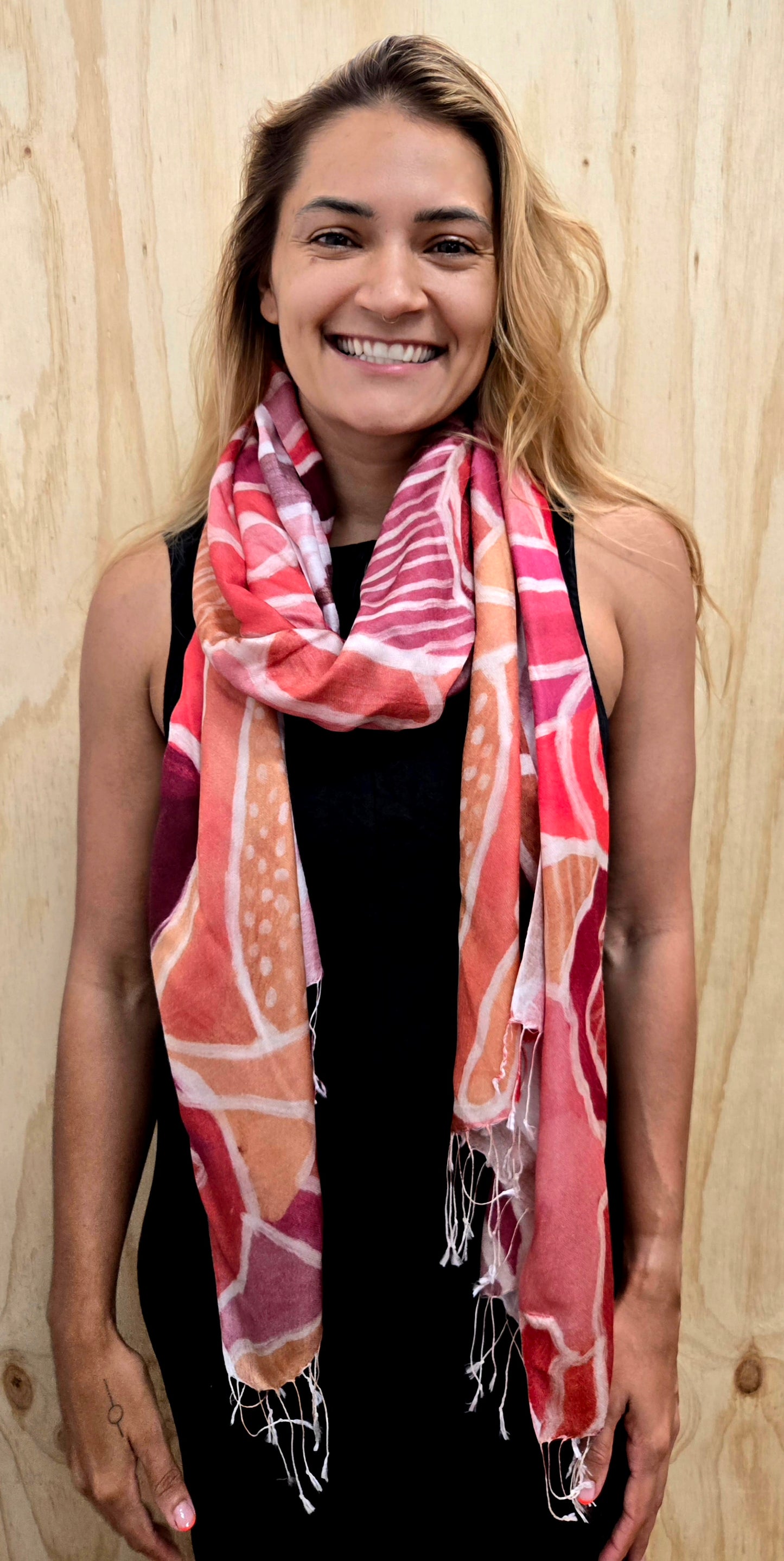 An Aboriginal woman wearing a Aboriginal artwork scarf in mulberry silk