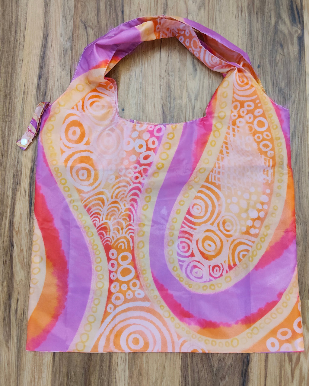 Colorful Aboriginal patterned bag on a wooden surface